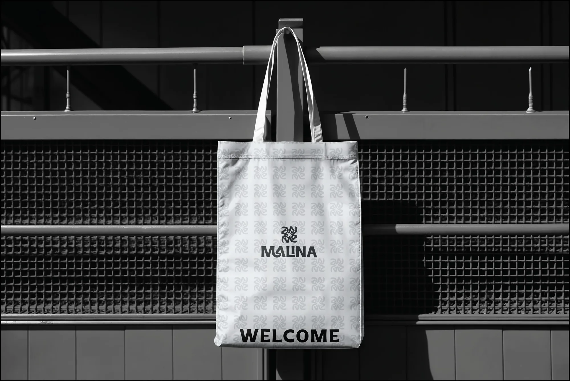 Malina tote bag hanging from a railing, Welcome print facing out